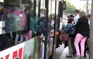 Usuaris de l'autobús pujant a un comboi ja molt ple, a la parada de Mallorca amb Lepant. ACN