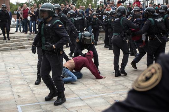 Agents de la Guàrdia Civil desallotgen alguns dels manifestants que s'havien assegut al terra per impedir l'accés al col·legi de Sant Julià de Ramis. 