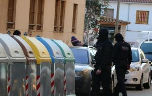 Agents dels Mossos d'Esquadra custodien el detingut, a qui han registrat el cotxe, abans de tornar al seu habitatge