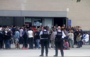 Cues a la porta del Centre Cívic de la Geltrú davant la mirada de dos mossos d'esquadra. Joan Maria Gibert