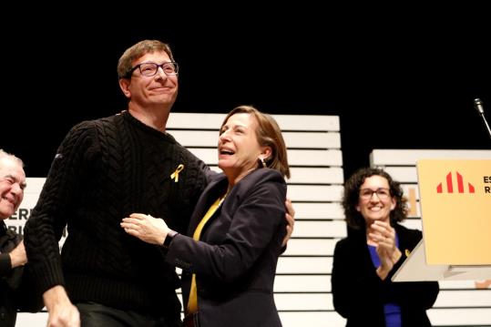 El conseller destituït de Justícia, Carles Mundó, abraça Carme Forcadell davant Marta Rovira, a l'acte d'inici de campanya d'ERC, a Vic. ACN