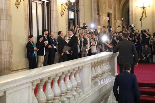 El president de la Generalitat, Carles Puigdemont, captat per desenes de càmeres i fotògrafs que l'esperaven al peu de l'escala del Parlament. ACN