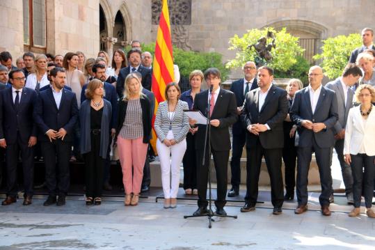El president de la Generalitat, Carles Puigdemont, des del Pati dels Tarongers del Palau de la Generalitat, flanquejats per la resta de l'executiu. AC
