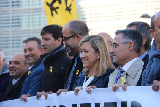 El president de l'ACM, Miquel Buch, i la de l'AMI, Neus Lloveras, sostenen la pancarta demanant des de Brussel·les l'alliberament de presos polítics. 