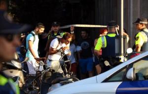 Els agents alcen el cordó policial perquè en surtin els ciutadans confinats per l'atemptat terrorista al centre de Barcelona. ACN