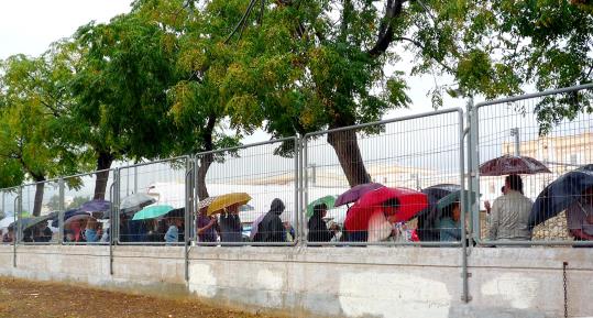 Gent fent cua sota la pluja a les portes d'un col·legi electoral. Rosa Maria Farriol
