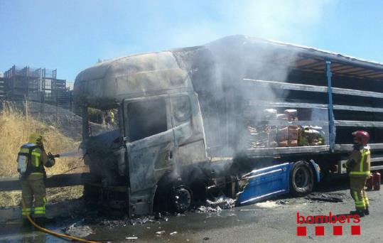 Imatge cedida pels Bombers de les tasques d'extinció d'un incendi a la cabina d'un camió que ha obligat a tallar l'AP-7 en sentit nord als Monjos. Mos