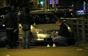 Imatge de dos agents inspeccionant el vehicle tirotejat a la Meridiana de BArcelona l'1 de gener de 2017. ACN