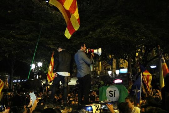 Imatge de Jordi Cuixart i Jordi Sànchez dirigint-se als manifestants a sobre d'un cotxe patrulla de la Guàrdia Civil. ACN