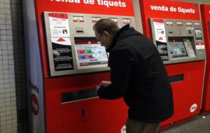 Imatge d'un usuari de metro agafant un bitllet de la màquina expenedora el 28 de desembre del 2017. ACN