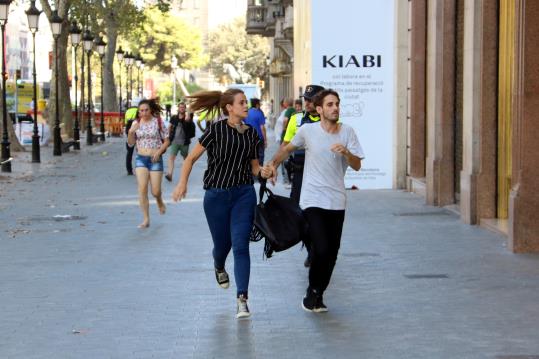 Persones corrent direcció Gran Via per Passeig de Gràcia, el 17 d'agost del 2017 . ACN