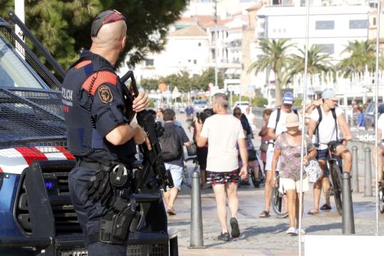 Pla americà d'un agent dels Mossos d'Esquadra armat vigilant a quarts de deu del matí d'aquest divendres, al passeig marítim de Cambrils. ACN