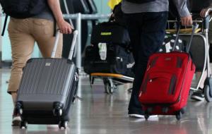 Pla detall de diverses maletes transportades per passatgers que circulen per la T1 de l'aeroport del Prat. ACN