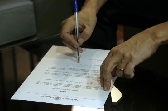 Pla detall del decret de suport al referèndum de l'1-O en el moment en què el signa l'alcalde d'Igualada, Marc Castells. ACN