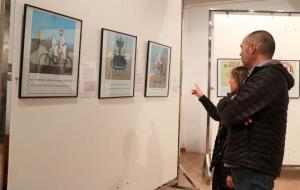 Pla general de dues persones visitant l'exposició 'LAuca de Rusiñol' de l'IEs Joan Ramon Benaprès de Sitges. ACN