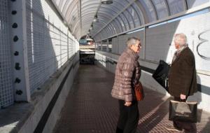 Pla general, des de l'exterior, de l'accés secundari de l'estació de Vilanova i la Geltrú tancat al públic, amb dues persones que volien utilitzar-lo 