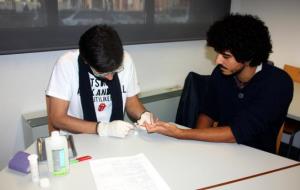 Pla mig d'un jove sotmetent-se a la prova ràpida de detecció del VIH per part d'un tècnic de l'Associació Antisida de Lleida. ACN