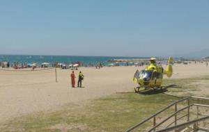 Pla obert de la platja amb l'helicòpter a la sorra. ACN