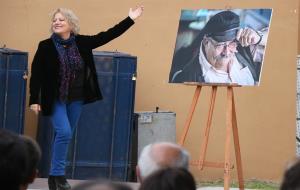 Pla obert de Marina Rosell somrient senyalant la fotografia de Pere Tàpies durant l'homenatge a l'artista, després de la seva mort
