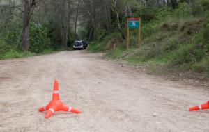 Pla obert d'un vehicle dels Mossos d'Esquadra davant la cinta policial que delimita el camí on s'ha trobat un cos calcinat, prop del Pantà de Foix