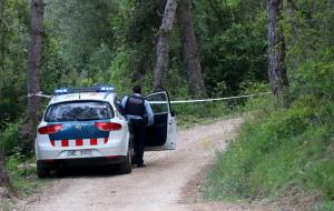 Pla obert d'un vehicle dels Mossos d'Esquadra davant la cinta policial que delimita el camí on s'ha trobat un cos calcinat, prop del Pantà de Foix
