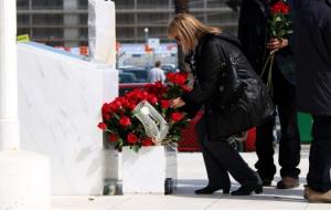 Pla obert d'una afectada per la tragèdia de Germanwings deixant una rosa al monument de la T2 del Prat, durant l'acte d'homenatge a les víctimes . ACN
