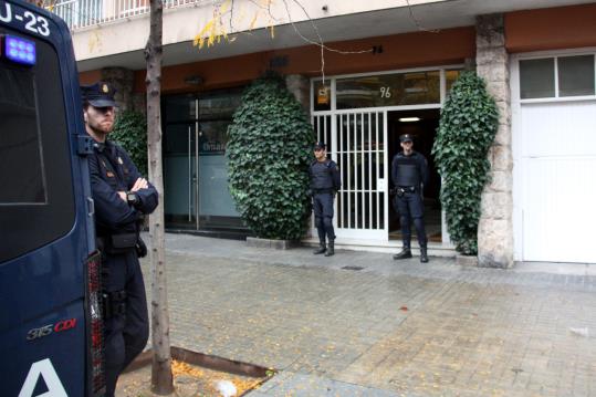 Tres agents de la policia espanyola custodien l'entrada de l'edifici on viu l'expresident de la Generalitat Jordi Pujol. ACN