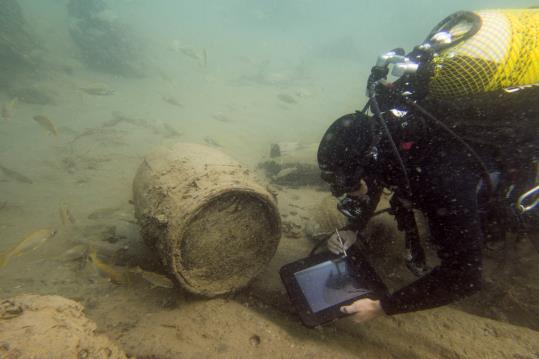 Un arqueòleg estudiant les restes del derelicte Deltebre I, enfonsat l'any 1813. En aquesta part del jaciment, s'hi aprecia un barril. ACN