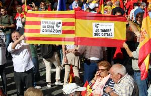 Un parell de manifestants mostren els cartells reivindicant una Catalunya dins d'Espanya