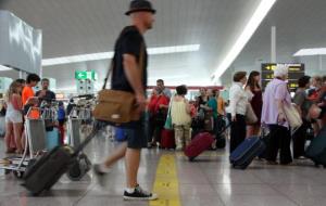 Un passatger travessa la T1 de l'aeroport del Prat, en una imatge d'arxiu de l'1 d'agost del 2014. ACN