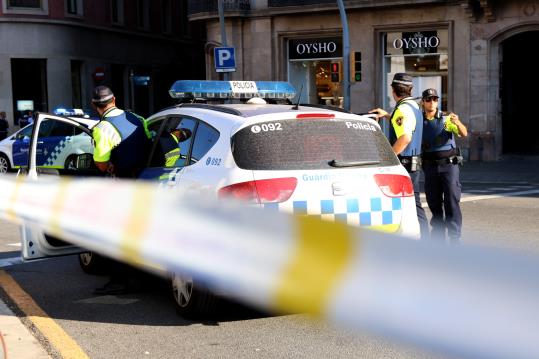 Un vehicle amb agents de la Guàrdia Urbana davant del cordó policial del carrer Pelai de Barcelona, el 17 d'agost de 2017. ACN