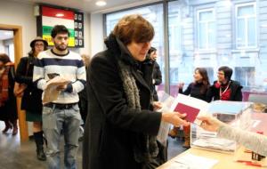 Una dona recull la seva documentació després de votar a l'oficina consular de Brussel·les. Darrere, un noi fa cua per dipositar el seu vot . ACN
