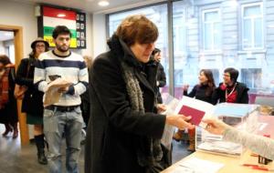 Una dona recull la seva documentació després de votar a l'oficina consular de Brussel·les. Darrere, un noi fa cua per dipositar el seu vot . ACN