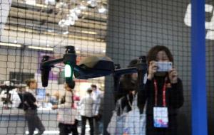 Una noia fotografia un dron en ple vol des de l'exterior del tancat habilitat al Mobile World Congress 2017. En primer terme, l'aeronau. ACN