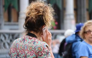 Una turista parla a través de seu telèfon mòbil a Brussel·les, el 13 de juny