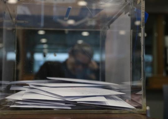 Una urna, a l'oficina consular d'Espanya a Brussel·les. De fons, un home esper a la sala de votació. ACN