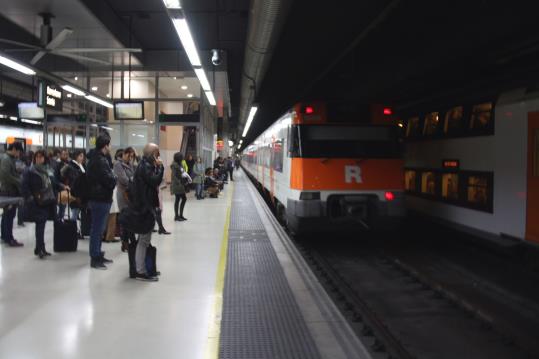Usuaris de Rodalies esperen per pujar a un tren a l'estació de Sants. ACN