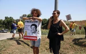 A la dreta, la germana de Dolors Bassa amb un cartell seu a Figueres el 4 de juliol del 2018. ACN