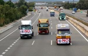 Camions amb pancartes enganxades al frontal, durant la marxa lenta d'aquest 11 d'octubre del 2018 a les comarques gironines. ACN