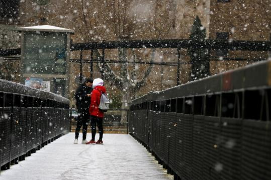 Dos adolescents sota la neu al pont de Tordera, el 8 de febrer de 2018. ACN