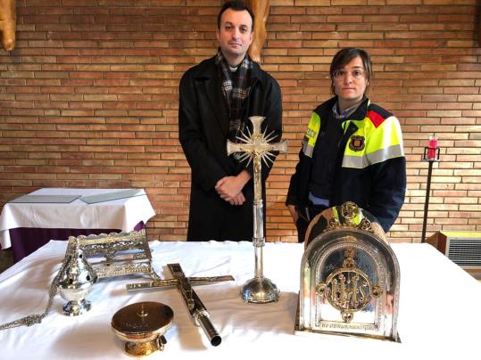El mossèn de la Sagrada Família d'Igualada amb una agent dels Mossos i els objectes religiosos. Mossos d'Esquadra