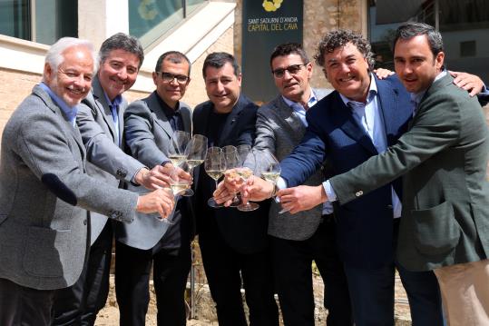 Imatge conjunta dels representants de les sis empreses de la marca d'escumosos de qualitat Corpinnat, brindant, amb el cuiner Josep Roca al centre. AC