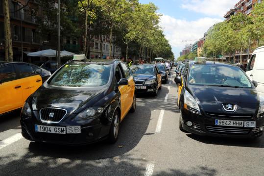 Imatge de taxis ocupant els tres carrils de circulació i aturant el trànsit a la Gran Via de Barcelona aquest 27 de juliol de 2017. ACN