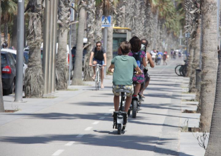 Imatge general on es poden veure turistes en patinet a motor al front marítim de Barcelona, on està prohibida la seva circulació. ACN