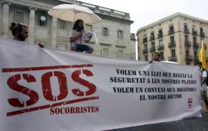 Pla detall de la pancarta central a la concentració de socorristes de Plaça Sant Jaume amb la plataforma SOS Socorristes. ACN