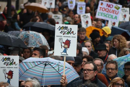 Pla detall d'un rètol exhibit a la manifestació 'L'escola catalana no té por' enmig d'una munió de gent. ACN