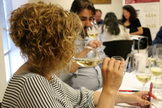 Pla detall d'una dona tastant un vi durant una jornada de puntuació dels premis Vinari 2018. ACN