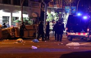 Pla general d'agents antidisturbis dels Mossos d'Esquadra retirant contenidors tombats al mig del carrer a Barcelona durant els aldarulls posteriors .