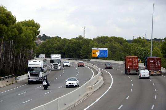 Pla general de camions circulant per l'AP-7, a l'alçada de Roda de Berà, amb un cartell indicatiu de diversos municipis de la Costa Daurada. ACN