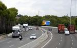 Pla general de camions circulant per l'AP-7, a l'alçada de Roda de Berà, amb un cartell indicatiu de diversos municipis de la Costa Daurada. ACN
